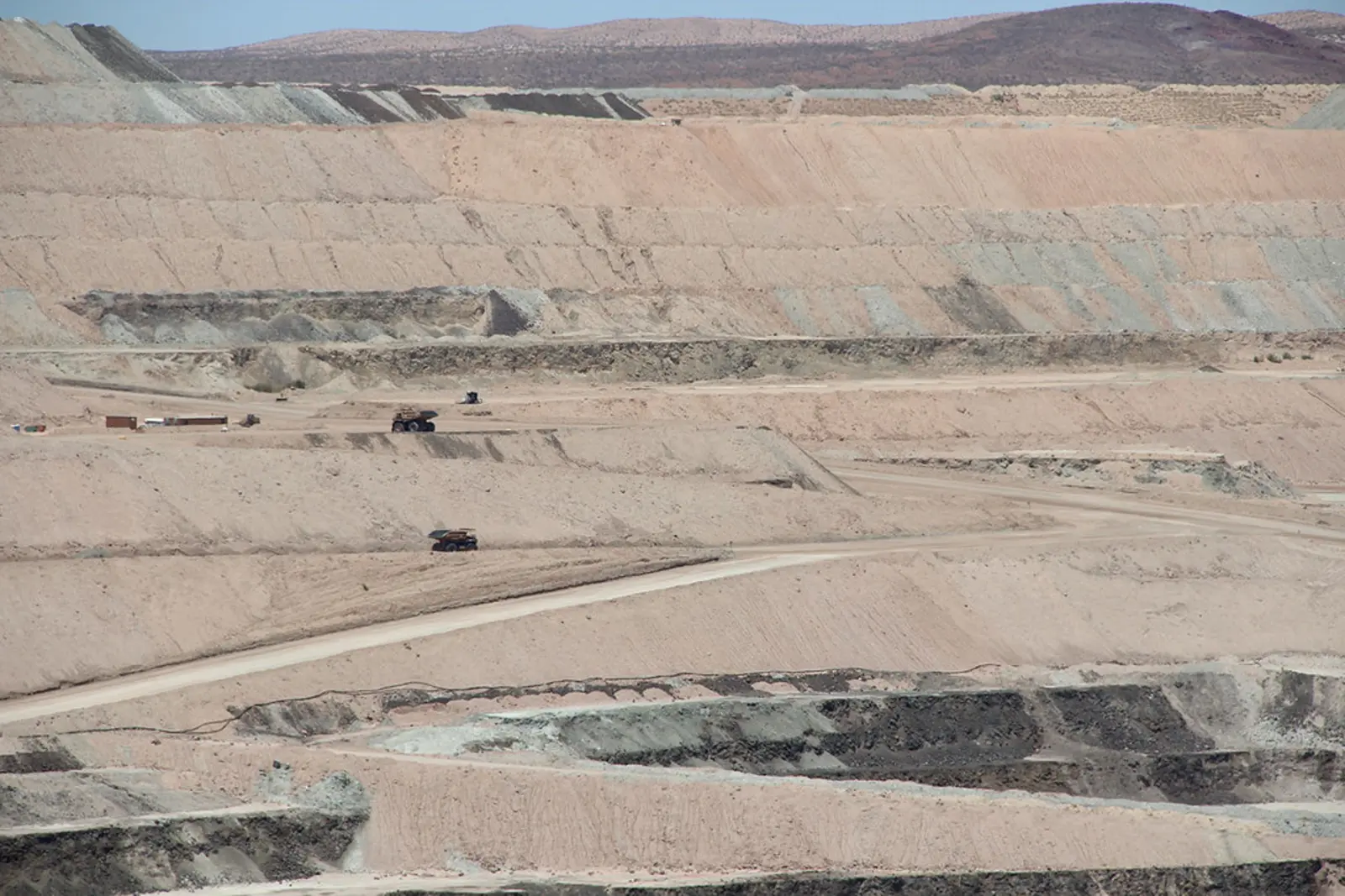 A terraced open-pit mine with winding dirt roads and heavy machinery operating in the distance under a clear sky. The photographer titled it “Borax Boron Open Pit Mine, Boron, California”.