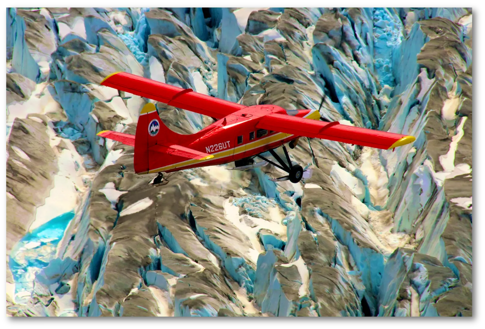 A red airplane flies over a glacier. The photographer titled it “NASA Airborne Campaigns Focus on Climate Impacts in the Arctic”.